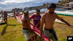 Rapanuis crew members carry their canoe during a training session for the Hoki Mai challenge, a voyage covering almost 500 kilometers across a stretch of the Pacific Ocean, in Rapa Nui, better known as Easter Island, Nov. 24, 2022.