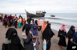 Etnis Rohingya berjalan ke tempat penampungan sementara setelah mereka mendarat dengan perahu kayu mereka di Aceh Utara, Rabu, 16 November 2022. (AP/Zik Maulana)