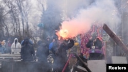 Para demonstran aktivis iklim melemparkan bom Molotow dan kembang api ke arah polisi, dalam upaya menghalangi penghancuran sebuah desa bagi perluasan tambang lignit terbuka Garzweiler di Luetzerath, Jerman, 11 Januari 2023.