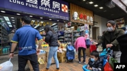 Shoppers are pictured outside a dispensary in Sheung Shui, Hong Kong, Jan. 4, 2023, ahead of the opening of the border with China on Jan. 8. Hong Kongers worried about the possible influx of COVID-19 strains have raced to buy nonprescription drugs for alleviating symptoms. 