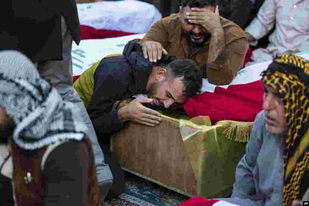 Луѓето тагуваат над ковчезите на луѓето убиени во напад на милитантите за време на нивниот погреб во Наџаф, Ирак. Осум лица беа убиени во нападот на вооружени лица на мотори, соопштија официјални лица.