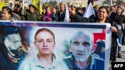  25일 시리아 쿠르드족이 시리아 북동부 도시 하사케에서 프랑스 파리 총격으로 희생된 3명의 사진이 담긴 현수막을 들고 있고 시위를 진행중이다.