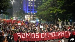 Manifestan kenbe yon banye ki di an Potige "Nou se Demokrasi" pandan yon manifestasyon pou mande pou pwoteje demokrasi peyi a, nan Sao Paulo, Brezil, 9 Janvye 2023.