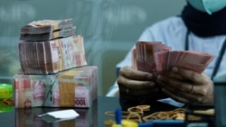 ILUSTRASI - Seorang teller menghitung uang kertas rupiah di money changer di Jakarta, 14 Oktober 2022. (Willy Kurniawan/REUTERS)