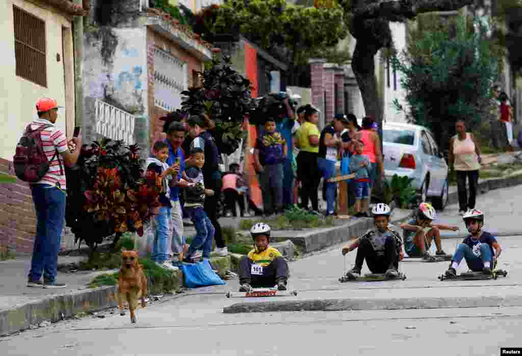 Children participate in a traditional street race with wooden makeshift carts called "carruchas", in Caracas, Venezuela, Dec. 17, 2022. 