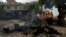 Investigators examine the wreckage of a car at the site of bomb explosion, in Islamabad, Pakistan, Dec. 23, 2022. 