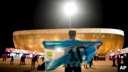 A man holds an Argentinian flag before the World Cup quarterfinal soccer match between the Netherlands and Argentina, outside the Lusail Stadium in Lusail, Qatar, Dec. 9, 2022. 