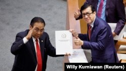 Yasonna Laoly, Menteri Hukum dan HAM, menerima laporan KUHP baru dari Bambang Wuryanto, dalam rapat paripurna parlemen di Jakarta, 6 Desember 2022. (Foto: REUTERS/Willy Kurniawan)