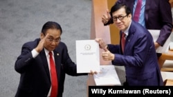 Yasonna Laoly, Indonesian Minister of Law and Human Rights, receives the new criminal code report from Bambang Wuryanto, head of the parliamentary commission overseeing the revision, during a parliamentary plenary meeting in Jakarta, Indonesia, December 6, 2022. 