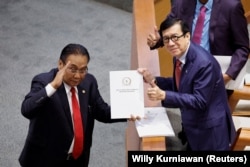 Yasonna Laoly, Menteri Hukum dan HAM, menerima laporan KUHP baru dari Bambang Wuryanto, dalam rapat paripurna parlemen di Jakarta, 6 Desember 2022. (Foto: REUTERS/Willy Kurniawan)