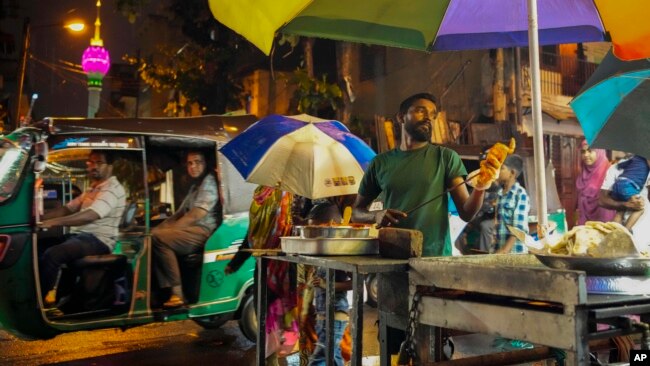 A street vendor prepares food in Colombo, Sri Lanka, Wednesday, Dec. 28, 2022. (AP Photo/Eranga Jayawardena)