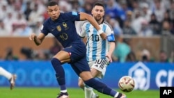 France's Kylian Mbappe and Argentina's Lionel Messi go for the ball during the World Cup final soccer match between Argentina and France at the Lusail Stadium in Lusail, Qatar, Sunday, Dec.18, 2022. (AP Photo/Manu Fernandez)