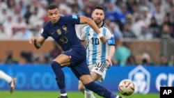 Kylian Mbappe dari Prancis dan Lionel Messi dari Argentina berebut bola pada laga final Piala Dunia antara Argentina dan Prancis di Stadion Lusail di Lusail, Qatar, Minggu, 18 Desember 2022. (Foto: AP/Manu Fernandez)