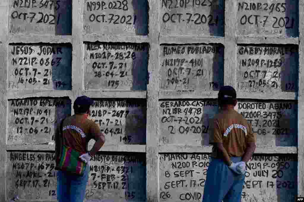 Prison inmates look at tombs during a mass burial of 70 unclaimed bodies of prisoners at New Bilibid Prison Cemetery in Muntinlupa, metro Manila, Philippines.(Photo by JAM STA ROSA / AFP)