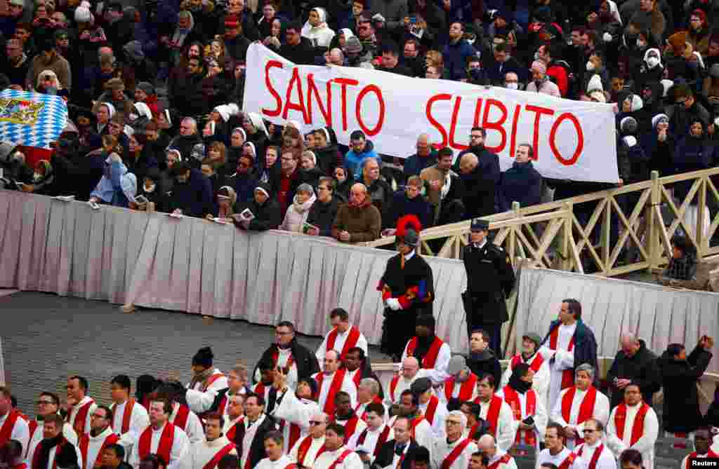 Faithful hold a banner that reads 'Saint now', during the funeral of former Pope Benedict, in St. Peter's Square at the Vatican, Jan. 5, 2023. 