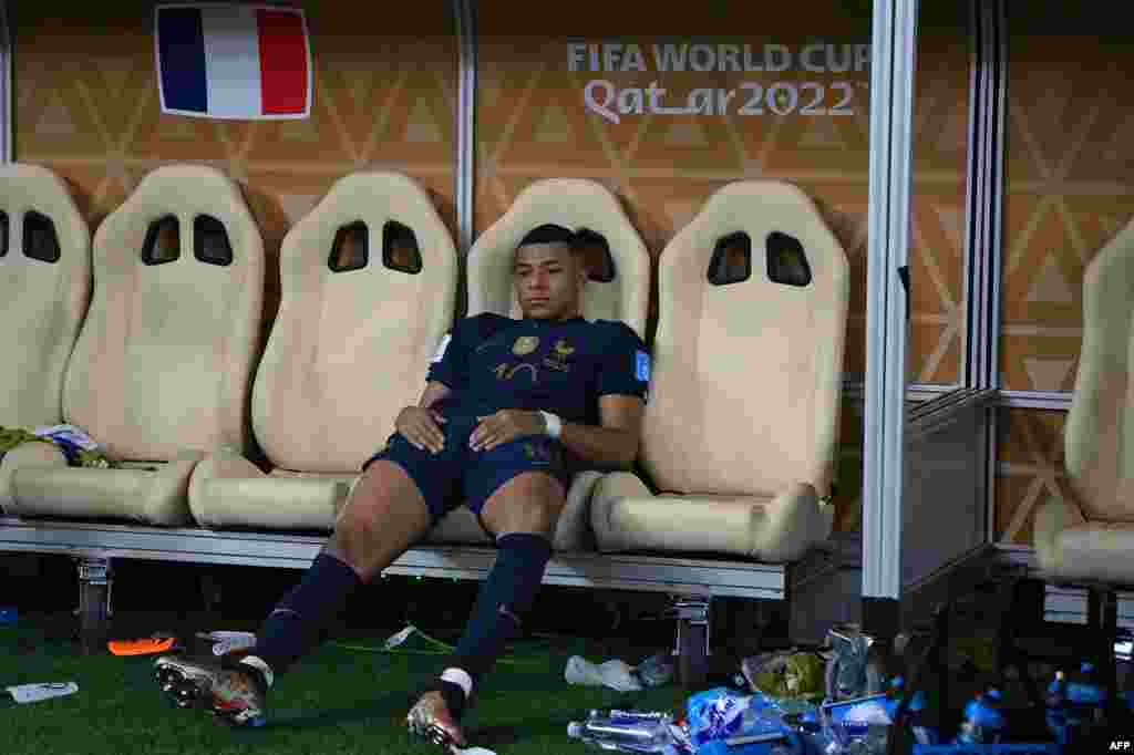 Penyerang Prancis Kylian Mbappe terduduk lesu, setelah kalah dalam adu penalti pertandingan final sepak bola Piala Dunia Qatar 2022 antara Argentina vs. Prancis di Stadion Lusail, utara Doha, Qatar, Minggu (18/12). (Foto: AFP)&nbsp;