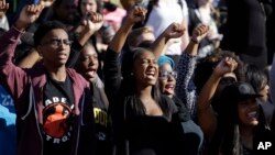 FILE - In this Nov. 9, 2015, photo, students cheer while listening to members of the black student protest group Concerned Student 1950.