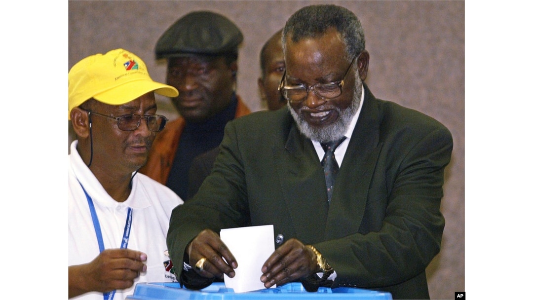 FILE - Namibian President Sam Nujoma, right, casts his vote as an unidentified election worker looks on during the Day 1 of the 2004 elections in Windhoek, Namibia, Nov. 15, 2004.