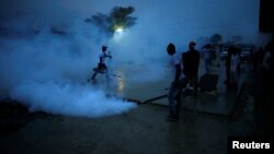 Workers of the Ministry of Public Health and Population fumigate a street during a campaign against mosquito breeding to prevent Zika in Port-au-Prince, Haiti, Sept. 7, 2016. 
