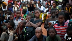 Children watch pro-government supporters gathering for an election rally in Bamako, Mali.