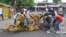 People inspect a damaged tricycle at the site of a bomb explosion, caused by a female suicide bomber in a market in Maiduguri, Nigeria, July 31, 2015. 