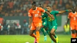 Ivory Coast's Sebastien Haller challenges for the ball against Senegal's Iliman Ndiaye during the 2023 African Cup of Nations Round of 16 soccer match, at the Charles Konan Banny stadium in Yamoussoukro, Ivory Coast, Monday, Jan. 29, 2024.