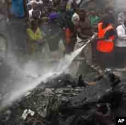 'Yan kallo sun taru yayin da 'yan kwana-kwana ke kokarin kashe wutar da ta tashi lokacin da jirgin saman kamfanin Dana Airlines ya fadi a wata unguwar Lagos bayan tasowar shi daga Abuja ranar lahadi 3 Yuni, 2012.