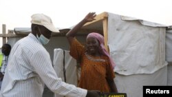 Un agent de sécurité fouille une femme au camp de réfugiés de Minawao à Minawao, au Cameroun, le 15 mars 2016.
