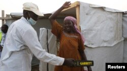 Un agent de sécurité fouille une femme au camp de réfugiés de Minawao à Minawao, au Cameroun, le 15 mars 2016.