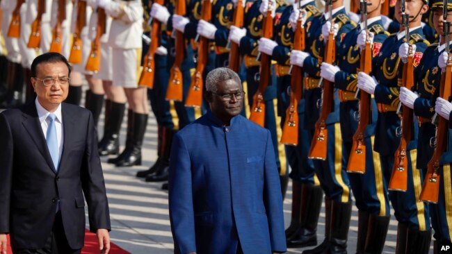 In this file photo, Chinese Premier Li Keqiang, left, and Solomon Islands Prime Minister Manasseh Sogavare review an honor guard during a welcome ceremony at the Great Hall of the People in Beijing, Wednesday, Oct. 9, 2019. (AP Photo/Mark Schiefelbein, Fi