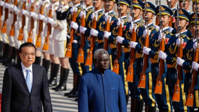 In this file photo, Chinese Premier Li Keqiang, left, and Solomon Islands Prime Minister Manasseh Sogavare review an honor guard during a welcome ceremony at the Great Hall of the People in Beijing, Wednesday, Oct. 9, 2019. (AP Photo/Mark Schiefelbein)