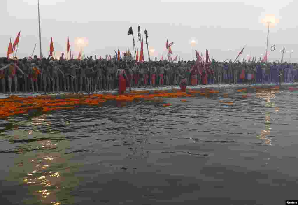 Hindu holymen prepare to take a holy dip during first grand bath of the Kumbh Mela, in the northern Indian city of Allahabad, January 14, 2013. 
