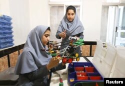 FILE - Members of Afghan robotics girls team work on their robots in Herat province, Afghanistan, July 4, 2017.