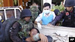 A Thai soldier injured in a fighting with Cambodia is helped by his comrades and a nurse after arriving at a hospital in Phnom Dongrak district of Surin province, northeastern Thailand, April 22, 2011