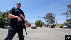 Офицер полиции у начальной школы в Сан-Бернардино в Калифорнии, где произошла стрельба. В результате инцидента погибли два человека. 10 апреля 2017 г.