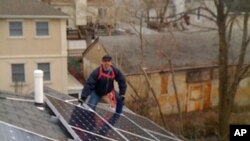 Carlos Berger installs solar panels on a single family home in Brooklyn, New York.