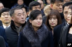 North Korean Hyon Song Wol, center, head of a North Korean art troupe, watches while South Korean protesters stage a rally against her visit in front of Seoul Railway Station in Seoul, South Korea, Jan. 22, 2018.