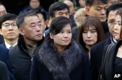 North Korean Hyon Song Wol, center, head of a North Korean art troupe, watches while South Korean protesters stage a rally against her visit in front of Seoul Railway Station in Seoul, Jan. 22, 2018.