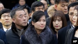 North Korean Hyon Song Wol, center, head of a North Korean art troupe, watches while South Korean protesters stage a rally against her visit in front of Seoul Railway Station in Seoul, South Korea, Monday, Jan. 22, 2018. 