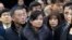 North Korean Hyon Song Wol, center, head of a North Korean art troupe, watches while South Korean protesters stage a rally against her visit in front of Seoul Railway Station in Seoul, South Korea, Monday, Jan. 22, 2018. 