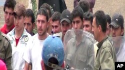 In this citizen journalism image provided by the Kfar Suseh Coordinating of the Syrian Revolution, taken on May 8, 2012, Syrian militiamen known as "shabiha" are seen standing in an alley inthe Kfar suseh area of Damascus, Syria.