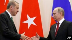 FILE - Russian President Vladimir Putin, right, and Turkish President Recep Tayyip Erdogan shake hands after a news conference in Putin's residence in Sochi, Russia, May 3, 2017.