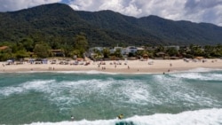 Surfers enjoy the waves during a local tournament at Maresias beach, in Sao Sebastiao, Brazil, Nov. 27, 2021.