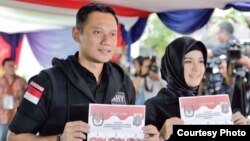 Calon gubernur Jakarta Agus Harimurti Yudhoyono bersama istri memberikan suara di sebuah TPS (15/2). (Courtesy: Anung Anindito)