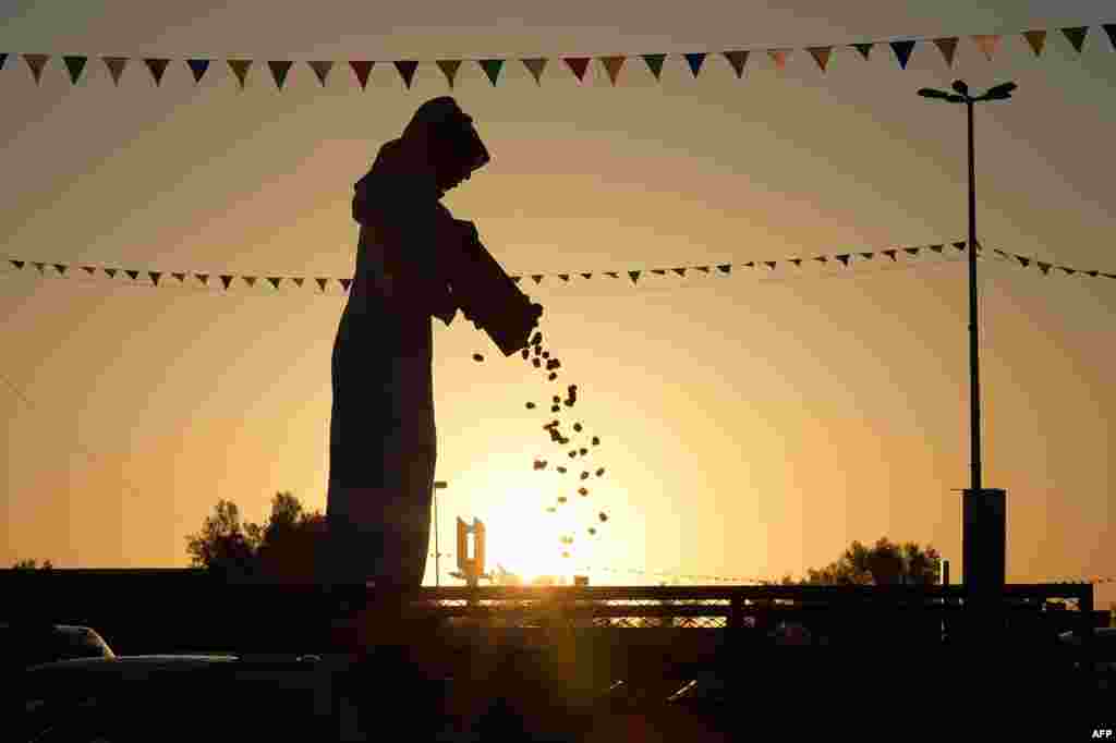 A Saudi man sells dates from the back of his trucks during the first day of the Buraydah Dates Festival in Buraydah, 400 kms northwest Riyadh. The festival site covers an area of 300,000 square meters that can accommodate 2,000 trucks and cold-storage vehicles.