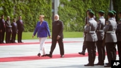German Chancellor Angela Merkel and Indian Prime Minister Narendra Modi review the honor guards before German-Indian government consultations at the chancellery Berlin, May 30, 2017. 