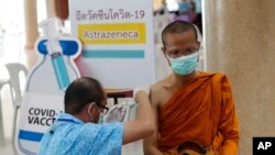 Seorang petugas kesehatan memberikan dosis vaksin AstraZeneca COVID-19 kepada seorang biksu Buddha di Kuil Nak Prok di Bangkok, Thailand, Jumat, 9 April 2021. (Foto: AP/Sakchai Lalit)
