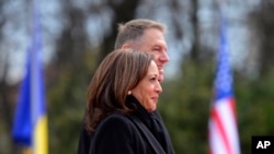 U.S. Vice President Kamala Harris, foreground, and Romanian President Klaus Iohannis attend a welcome ceremony in Bucharest, Romania, March 11, 2022. 
