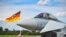 FILE - This file photo taken on Aug. 20, 2020 shows a man taking pictures of an Eurofighter jet of the German Air Force on the tarmac of the German Armed Forces (Bundeswehr) airbase in Noervenich, western Germany. 