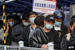 People queue up to be tested as a measure against COVID-19 at the Shanghai Jin'an Central Hospital, in Shanghai, March 11, 2022.